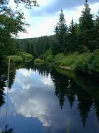 Clouds reflect in a deep mountain pool.